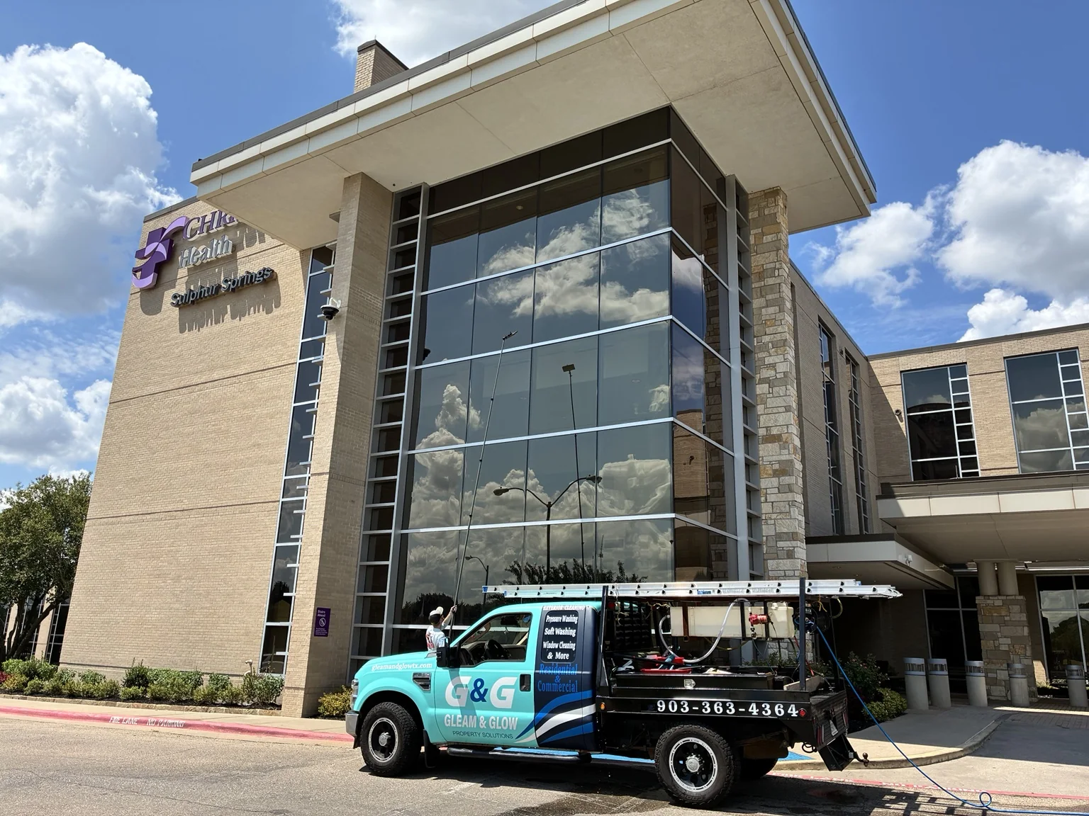 Gleam & Glow service truck at a commercial window-cleaning project