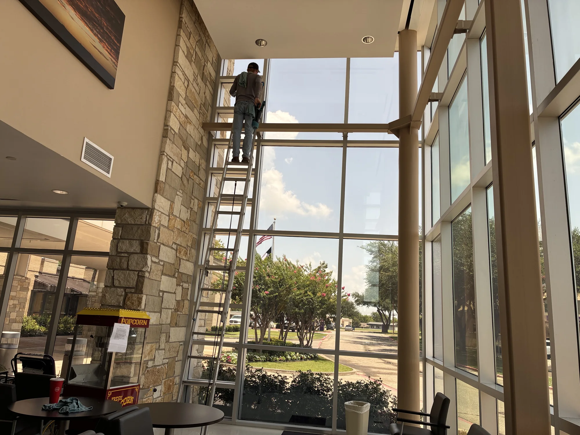 Technician cleaning tall interior windows